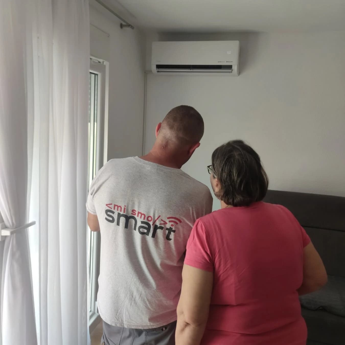 Tehničar SMART-a i kupac pored ugrađenog klima uređaja